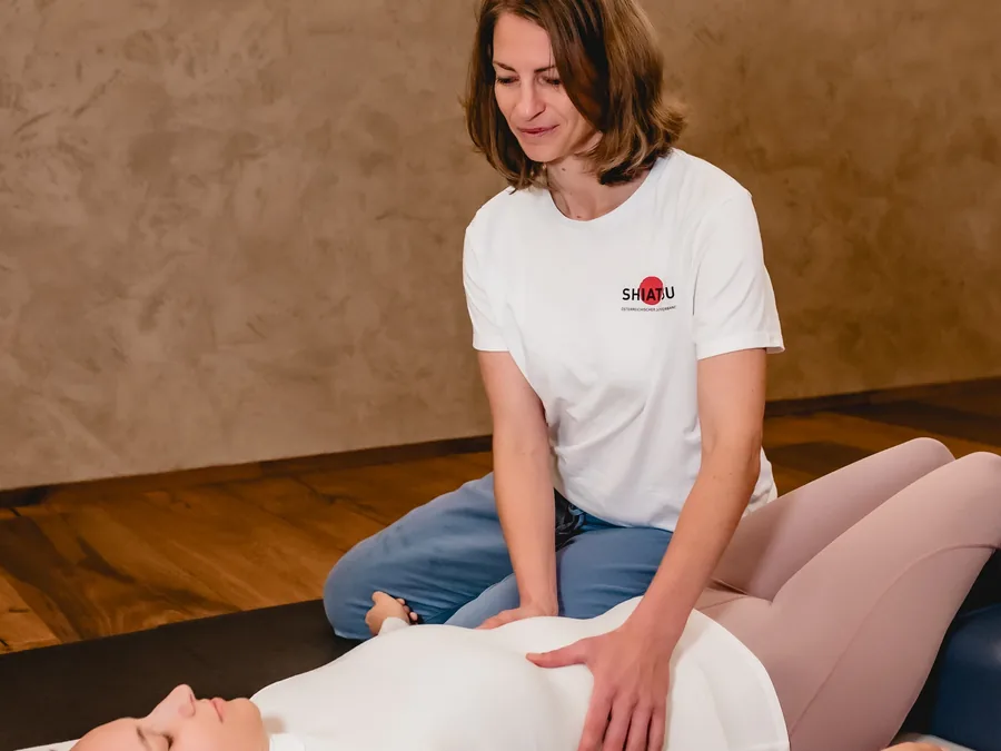 Shiatsu-Behandlung auf der Matte: Gabriele Loy arbeitet am Bauch einer liegenden Klientin